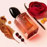 Perfume bottle with a red rose and dried leaves on a light pink background